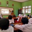 Guru menjelaskan materi pelajaran dengan bantuan proyektor, siswa-siswi tampak antusias menyimak di dalam kelas, Rabu (16/7/2023). Sumber foto: Esensi TV